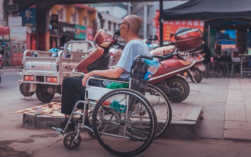 Man in a wheelchair at a market | © Unsplash