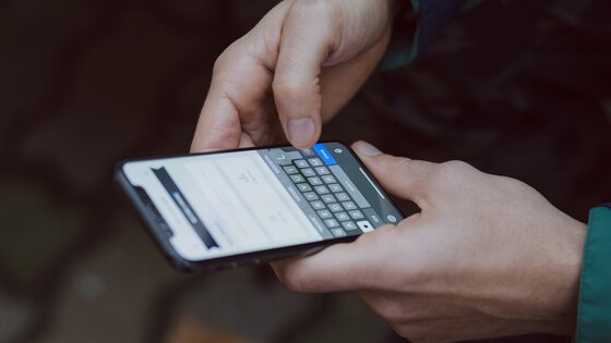 A man typing words on a phone screen | © Unsplash