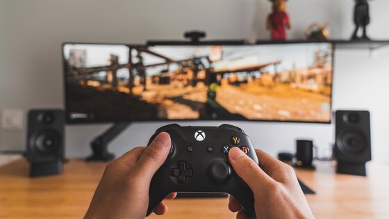 A person playing a video game with a controller | © Unsplash.com
