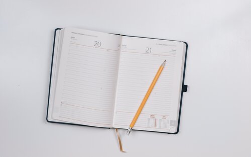 An open diary with a pencil | © Unsplash.com