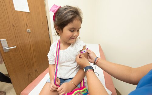 A child receiving a band-aid from a doctor | © Unsplash.com
